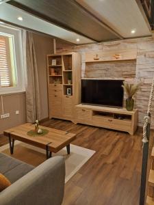 a living room with a large television and a table at Modern Apartment Baćo with Jacuzzi in Šibenik