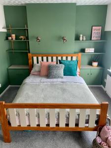 - une chambre avec un lit aux murs verts dans l'établissement La Brisa-fully refurbished, perfect local, à Portrush