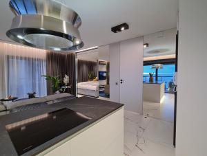 eine Küche mit einem Waschbecken und ein Wohnzimmer in der Unterkunft BALTIC VIEW Luxury Apartment Gardenia FRONT in Dziwnów