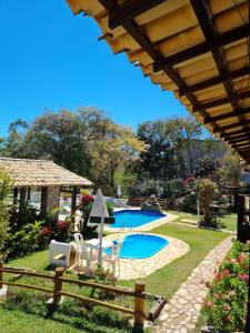 un patio trasero con piscina y una casa en Pousada Canto das Aguas, en Serra do Cipo