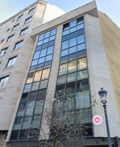 wysoki budynek ze szklanymi oknami i światłem ulicznym w obiekcie Atico con Terraza, Plaza América w mieście Vigo