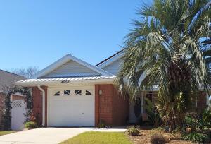 a palm tree in front of a house with a garage at Destin Daydream in Destin