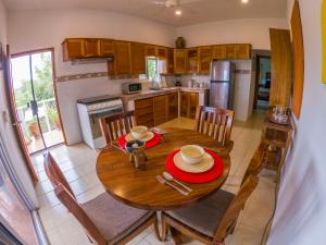 eine Küche und ein Esszimmer mit einem Holztisch und Stühlen in der Unterkunft La Hacienda Tilantongo in Puerto Escondido