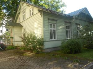 a green house with a driveway in front of it at Poska Villa Guesthouse in Tallinn