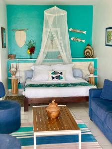 ein Schlafzimmer mit einem Bett und einer blauen Wand in der Unterkunft Résidence Cocody in Sainte-Anne