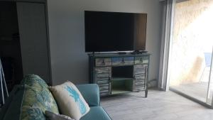 sala de estar con TV de pantalla plana en un soporte en 2BR/1BA Sienna Park, Sarasota Fl, en Sarasota