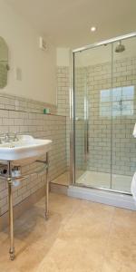 a bathroom with a glass shower and a sink at Kennington B & B in London