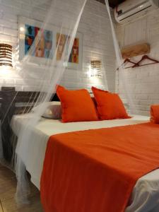 1 dormitorio con 2 camas con almohadas de color naranja en Villas de Tibau, en Pipa