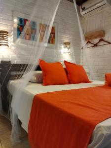 a bedroom with two beds with orange pillows at Villas de Tibau in Pipa