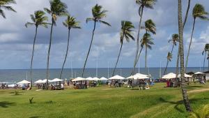 a group of palm trees and umbrellas on the beach at FLAT Jardim de Alah - Frente Praia in Salvador