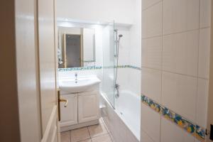 een witte badkamer met een wastafel en een douche bij Over Monaco Apartment - 100m from Monaco - Roof Swimming Pool in Beausoleil