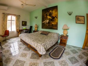ein Schlafzimmer mit einem Bett und einem Wandgemälde in der Unterkunft La Hacienda Tilantongo in Puerto Escondido