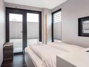 two beds in a room with two windows at Houseboat with Stunning Views in Sneek
