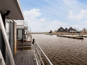 a boat on the water with houses in the background at Houseboat with Stunning Views in Sneek