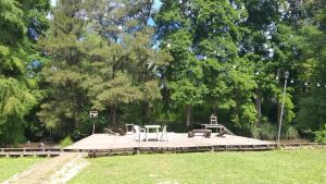 a park with benches and tables on a wooden deck at Cabañas Al Río Delta Tigre in Tigre