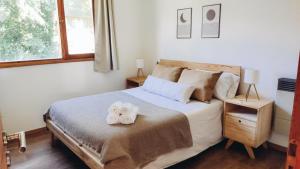 a bedroom with a bed with two towels on it at Casa con jardín y cochera ¡A 5 minutos del lago! in San Carlos de Bariloche
