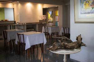 a restaurant with tables and chairs and a table with a stump at Hotel & Restaurante Paraíso - By Up Hotel in Ponte Nova