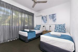 two beds in a room with a window at Seascape Holidays - Tropical Reef Apartments in Port Douglas