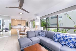 a living room with a couch and a table at Seascape Holidays - Tropical Reef Apartments in Port Douglas