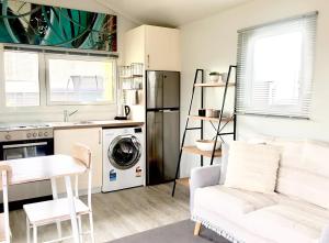 a kitchen with a washer and dryer and a white couch at Almond Court Motel in Alexandra