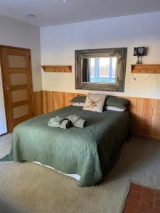 een slaapkamer met een groot groen bed en een spiegel bij Timber Trail Farmstay in Ongarue