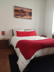 1 dormitorio con 1 cama con manta roja en Aveiro Theater Rooms, en Aveiro