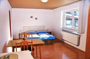 Schlafzimmer mit einem Bett, einem Tisch und einem Fenster in der Unterkunft Ubytovanie v Súkromi Habovka in Habovka