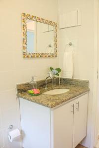 un baño con lavabo y espejo en REFÚGIO FAMILIA, descanso e conexão c natureza, en Ibiúna 47 fotos más