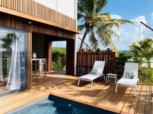 eine Terrasse mit 2 Stühlen und einem Pool in der Unterkunft ZANNANNA LODGE in Le Diamant