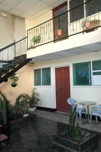 una casa con puerta roja, mesa y sillas en Hostal Nicaragua Guest House, en Managua