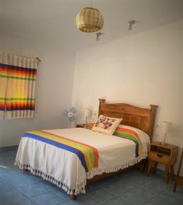 a bedroom with a bed with a colorful comforter at Casa de Alicia Habitación Monte Albán in Oaxaca City