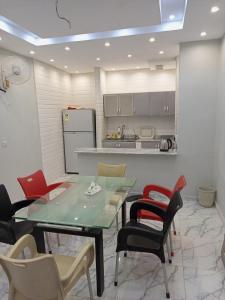 a dining room with a table and chairs and a kitchen at فيلا مطل الهدا in Al Hada