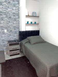 um quarto com uma cama e uma parede de tijolos em Green Space em Tarija