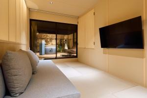 大阪KONJAKUSO Osaka Tempozan "IKESU" Projection M apping SPA "TAKADORO" Wheel View的配有沙发和平板电视的客厅