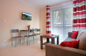 ein Wohnzimmer mit einem Sofa und einem Tisch in der Unterkunft Apartamenty Pod Izbicą in Karpacz