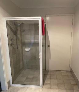 La salle de bains est pourvue d'une douche avec une porte en verre. dans l'établissement Thistle Do Bed and Breakfast, à Bridgetown