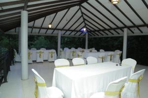 un chapiteau avec une table et des chaises blanches dans l'établissement Hotel Achivina, à Kandy