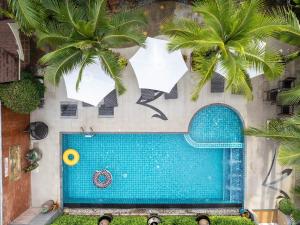 an overhead view of a swimming pool with two palm trees at Baan Sailom Hotel Phuket - Sha Extra Plus in Karon Beach