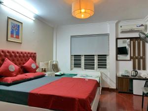 um quarto com uma cama vermelha e uma janela em Miah Boutique Homestay em Hanói