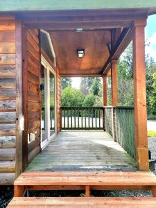 - une terrasse couverte en bois avec un banc en bois dans l'établissement The Bogi Bear Inn, à Forks