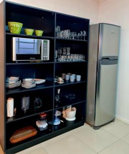 uma cozinha com uma prateleira preta e um frigorífico em Apartamento Major Nicoletti em Gramado
