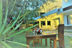 une table en bois devant une maison dans l'établissement Hotel Achivina, à Kandy