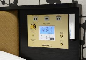 a tablet screen with a clock on a wall at APA Hotel Hakata Higashihieekimae in Fukuoka