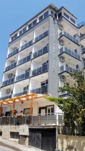 un edificio alto y blanco con ventanas laterales. en Room in Apartment - Kusadasi Residence 21 2 Bedroom and Living room, en Aydın