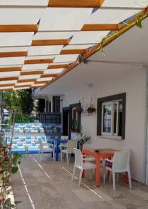 un patio con mesa y sillas bajo toldo en Room in Apartment - Kusadasi Residence 21 2 Bedroom and Living room, en Aydın