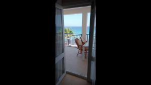 une porte ouverte s'ouvrant sur un balcon avec vue sur l'océan. dans l'établissement Room in Apartment - Kadinlar Denizi Ev 31, à Aydın