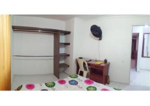 1 dormitorio con cama y escritorio. en Habitación privada en apartamento con terraza, en Bucaramanga