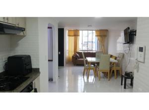 a kitchen and living room with a table and chairs at Habitación privada en apartamento con terraza in Bucaramanga