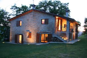 una gran casa de piedra con sus luces encendidas en Villa Podere Quartarola, en Modigliana