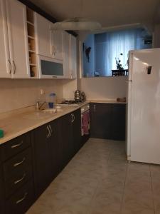 a kitchen with brown cabinets and a white refrigerator at 2 munites walk to Ladies Beach in Aydın